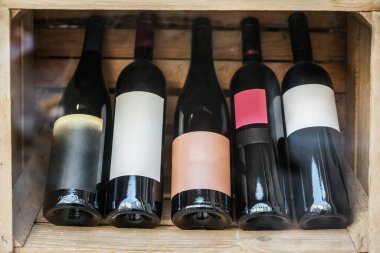 Şarap şişeleri ahşap bir kutuda, bir sürü şarap kutusu stokta. boş boşluk