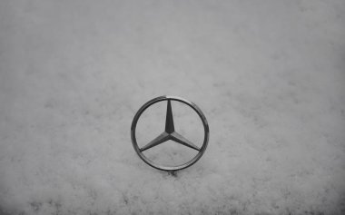 MUNICH, Almanya - 13 ARALIK 2019: Mercedes 'in üzerindeki amblem, karla kaplıydı.