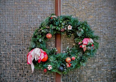 Gözlük kapısında Noel çelengi. Bir dükkanın ya da evin ön kapısında ladin ve süs eşyalarından yapılmış el yapımı geleneksel bir Noel çelengi asılı. Yeni yıla hazırlık konsepti..