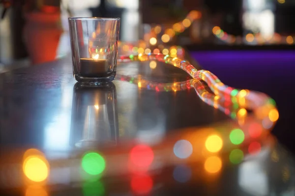 木製のテーブルの上にキャンドルや新年のガーランドと透明なガラス バーカウンターだ 夜のシーン — ストック写真