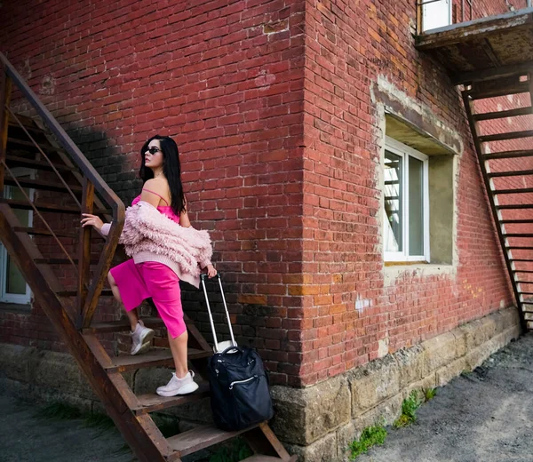 분홍색 여인이 가방을 계단을 오르고 — 스톡 사진