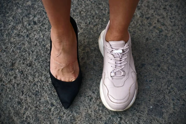 年轻女人换高跟鞋换舒适的运动鞋 顶视图 沥青背景 — 图库照片