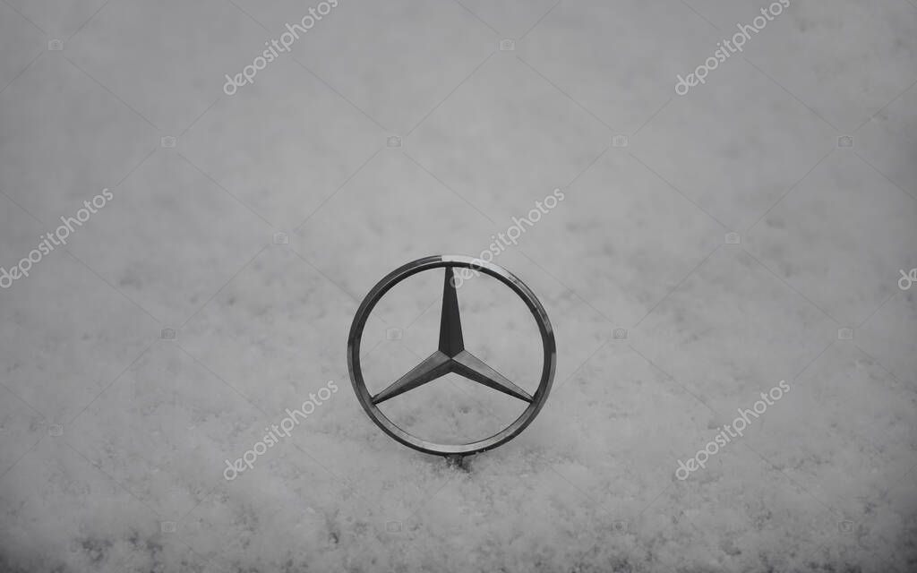 MUNICH, GERMANY - DECEMBER 13, 2019:  The emblem on the car brand Mercedes, covered with snow