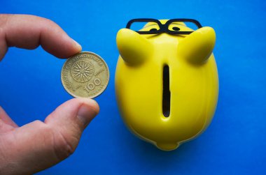 Erkek El, kumbaranın üzerinde bozuk para tutuyor.