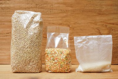 Beyaz pirinç, bezelye ve arpa dolu çantalar. tahta arkaplan.