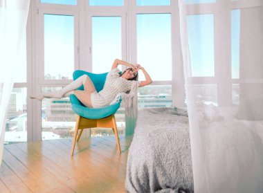 Genç sarışın kadın modern sandalyede oturuyor..