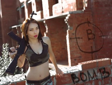 Elinde makineli tüfek tutan Asyalı kadın. Arkaplanı mahveder.