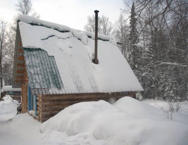 Kışın karla kaplı bir kulübe.