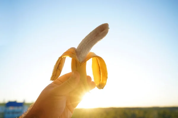 Mano Masculina Sosteniendo Plátano Amarillo Cielo Soleado —  Fotos de Stock