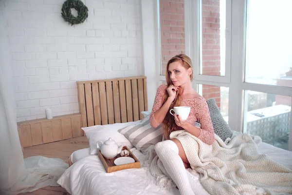 可愛いですブロンド女性朝のベッドにコーヒーカップ — ストック写真