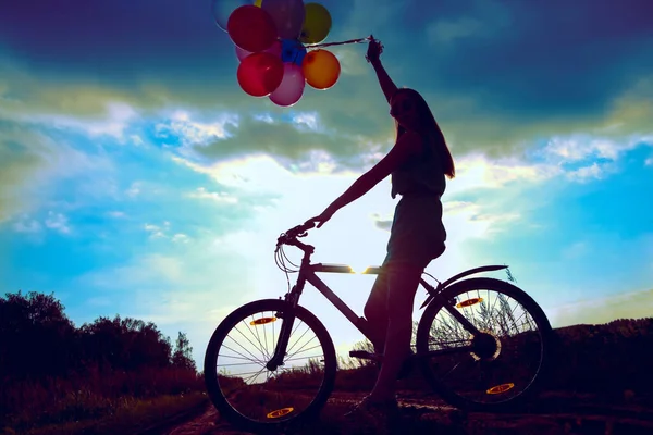 Young Girl in sexy dress  riding bicycle flying air balloons