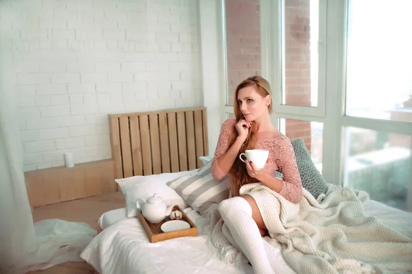 可愛いですブロンド女性朝のベッドにコーヒーカップ — ストック写真