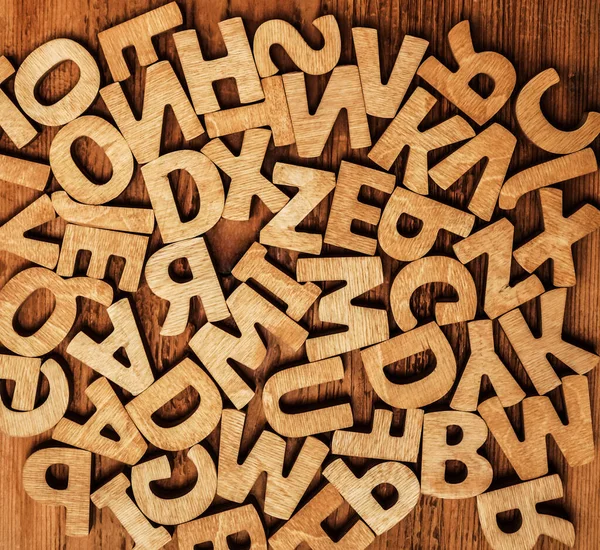 木制字母表字母隔离在木制背景上 很多木制信件 — 图库照片