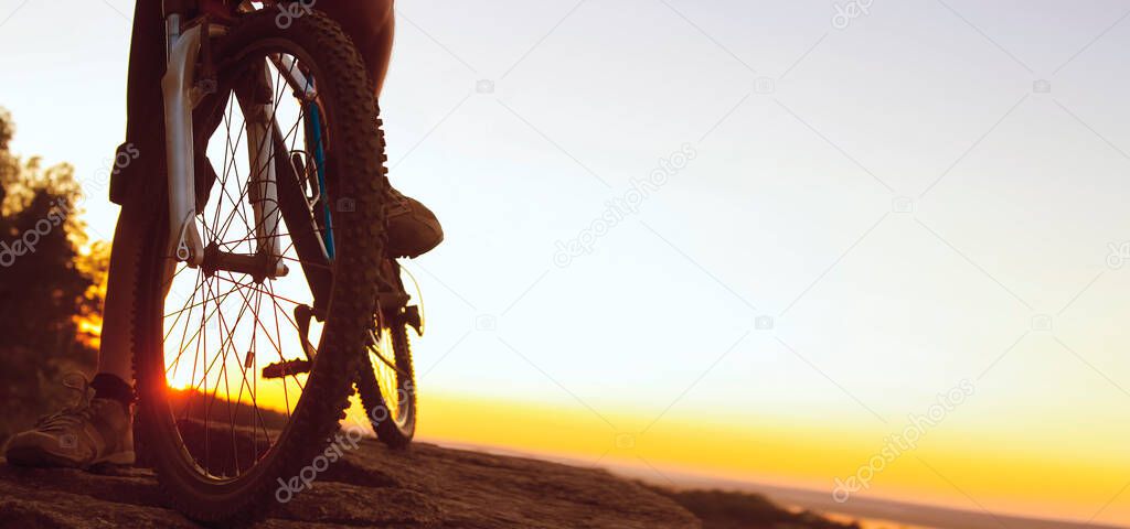 Silhouette of a bike. tourist on mountain peak. sunny dawn.