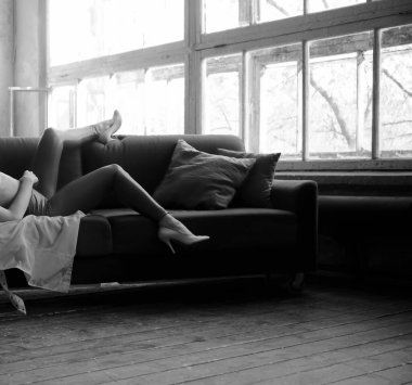 Rahat koltukta boş vakti olan bir kız. Kadınlar modern apartman dairelerinde eğleniyorlar. Yüzü yok.