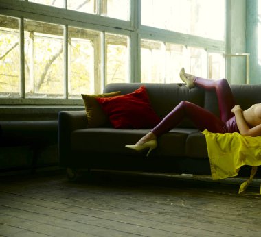 Rahat koltukta boş vakti olan bir kız. Kadınlar modern apartman dairelerinde eğleniyorlar. Yüzü yok.