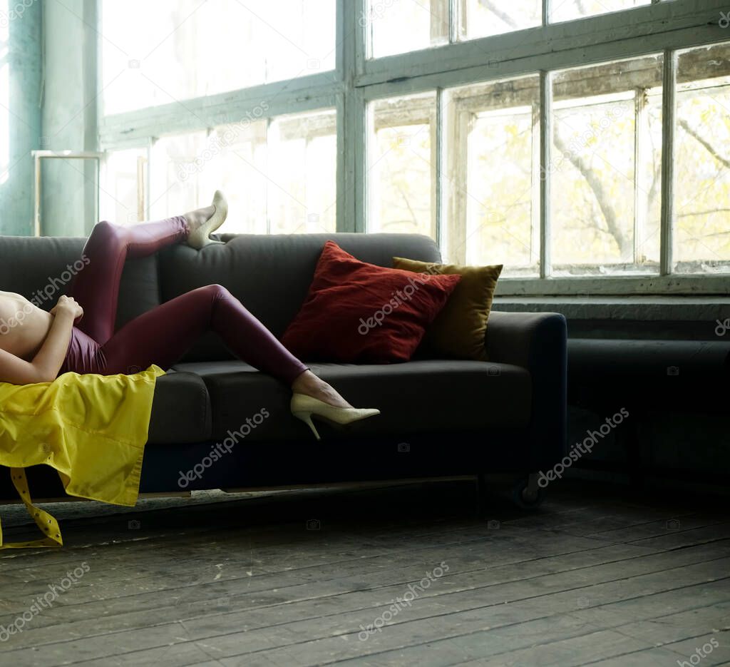 girl having free time on comfy sofa . Woman enjoyiing  in modern apartment indoors. no face.