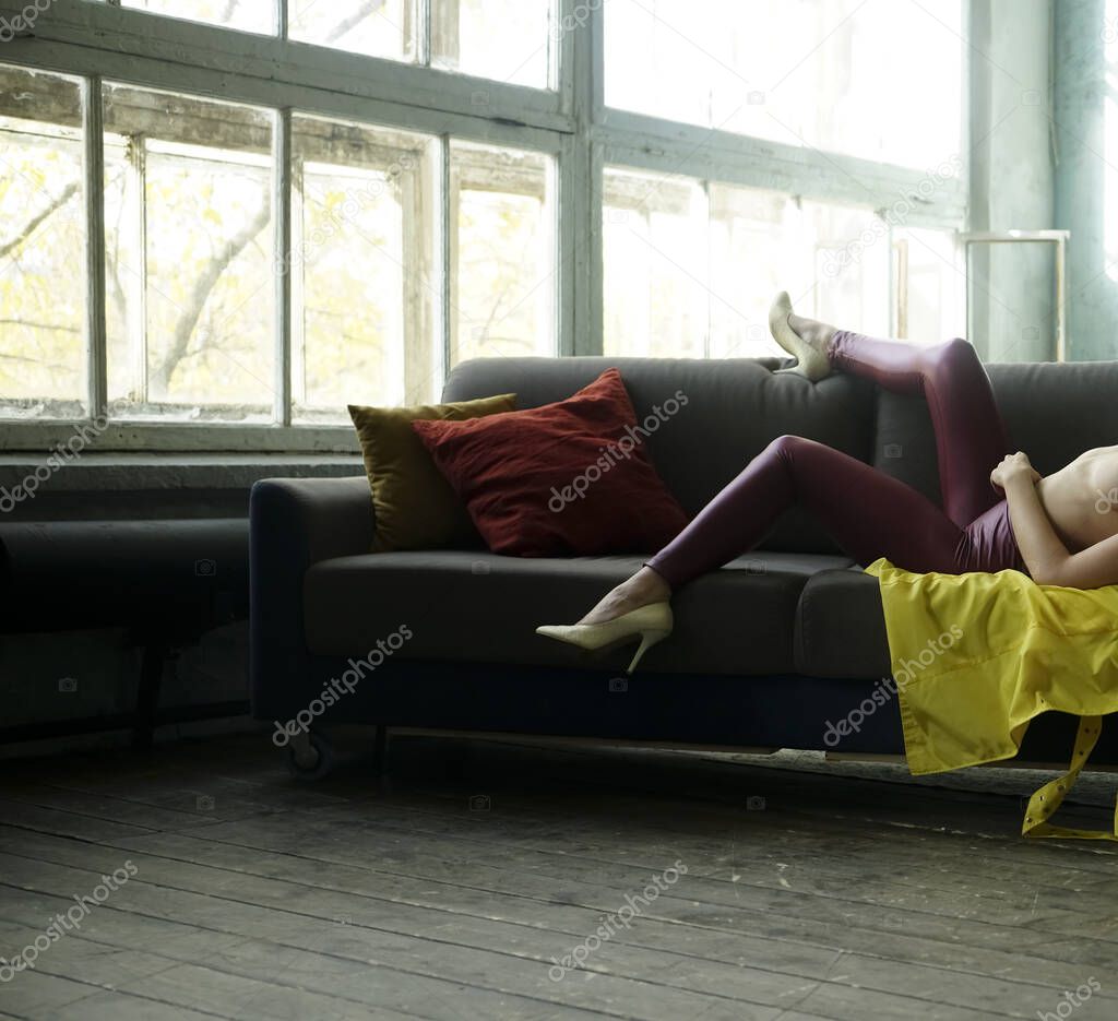 girl having free time on comfy sofa . Woman enjoyiing  in modern apartment indoors. no face.