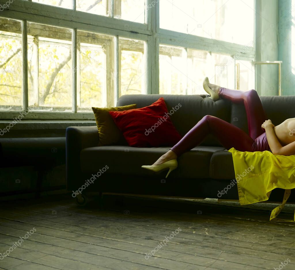 girl having free time on comfy sofa . Woman enjoyiing  in modern apartment indoors. no face.