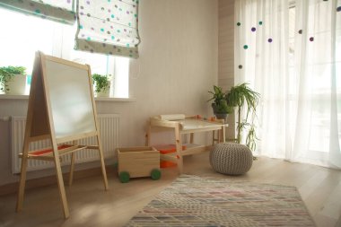 Taburesi ve resim masası olan anaokulu odası. Çocuk odası ve mobilya 