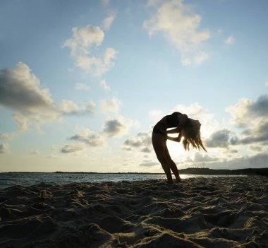 Gün batımı yogası. Hasta Uttanasana pozunda duran kadın, geri çekiliyor. Yoga inzivası. Omurga sağlam.. 