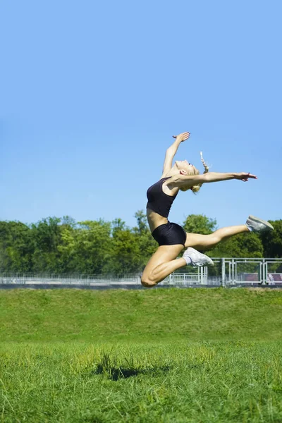 Una Hermosa Joven Deportista Saltando Parque Mientras Usa Pantalones Cortos —  Fotos de Stock