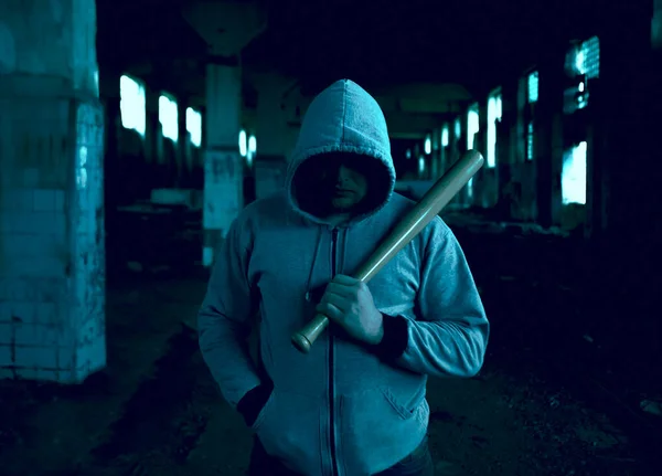 Aggressive man with a baseball bat wearing hoody