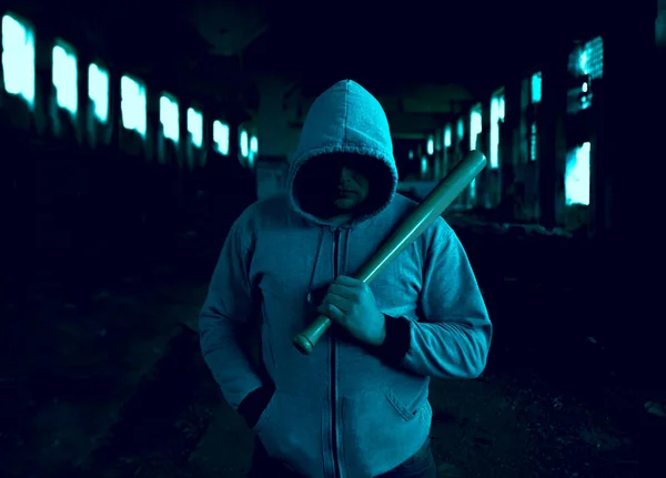 Aggressive man with a baseball bat wearing hoody