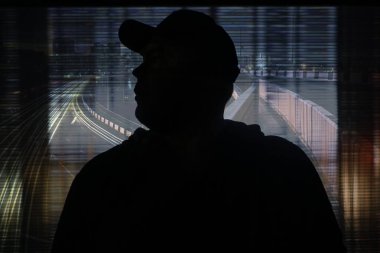 Gece şehrinin arka planında insan silueti.