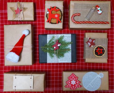 Noel kompozisyonu: Çam dalları, hediye kutuları, tahta geyik ve kırmızı masa örtüsü üzerinde Noel Baba şapkası. Mesaj için yer var. Üst Manzara. Düz yatıyordu. 2022 mutlu yıllar.