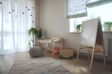 Taburesi ve resim masası olan anaokulu odası. Çocuk odası ve mobilya 