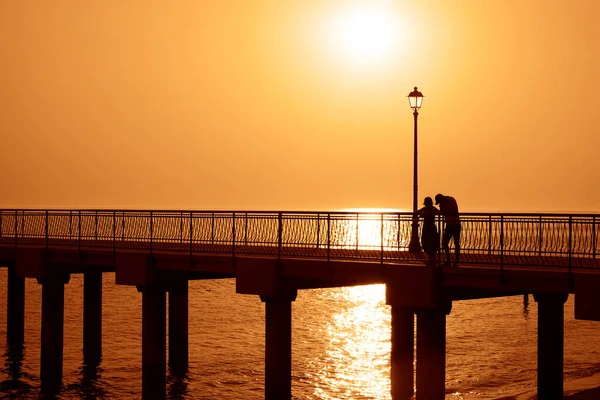 码头上的一对夫妇的轮廓 日落海滩 恋爱中的夫妻 — 图库照片