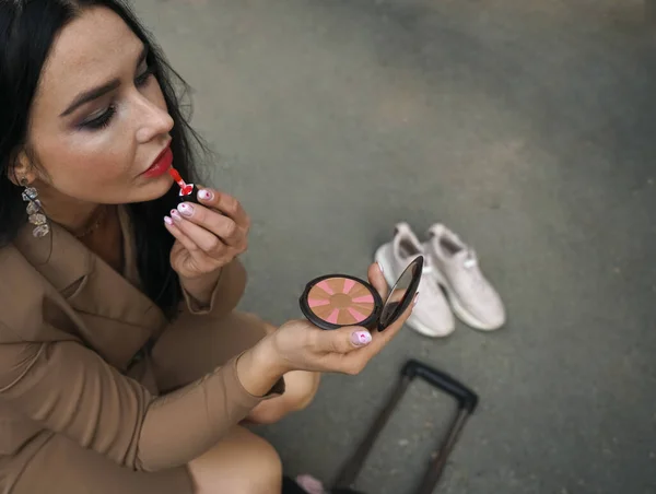 漂亮的女人在做化妆品的时候 在镜子里看着自己 — 图库照片