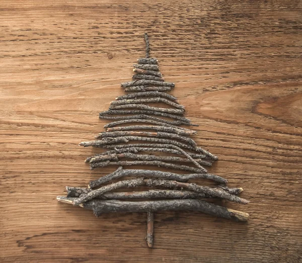 Christmas tree  from sticks on wooden  brown background. happy new year. Merry christmas.