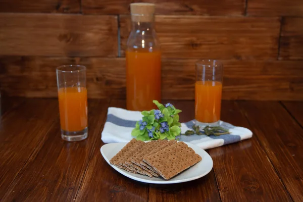 Fitness breakfast with freshly squeezed juice and crispbread on wooden background. Proper nutrition theme