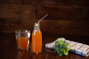 Vintage şişe suyu, saman ve ahşap masaya çiçek