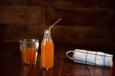 Vintage şişe suyu, saman ve ahşap masa üzerinde havlu ile