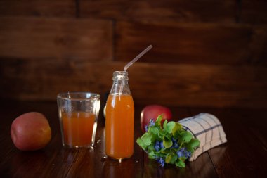 Vintage şişe suyu, saman, çiçek ve ahşap masa havluda