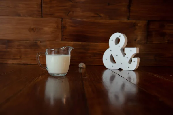 Leche en jarra de leche de vidrio y un ampersand brillante —  Fotos de Stock