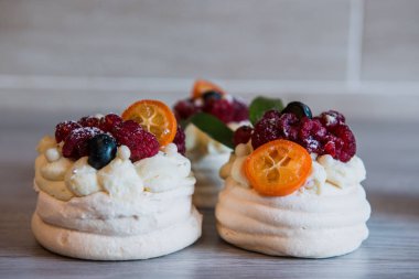 Pavlova beze pasta krem ve küçük meyve ile