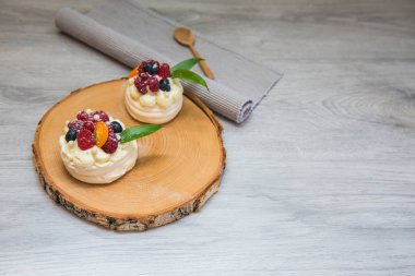 Pavlova beze pasta krem ve küçük meyve ile