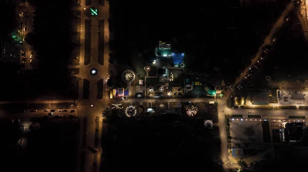 Children playground on yard activities in public park in the night lights. Aerial view