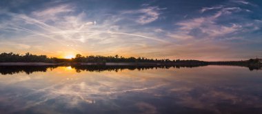 Yansıması ile güzel manzara, gün doğumunda mavi gökyüzü ve sarı güneş ışığı.