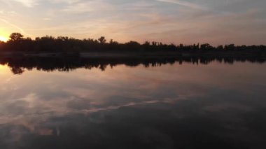 Yansıması ile güzel manzara, nehirde gün doğumu mavi gökyüzü ve sarı güneş ışığı