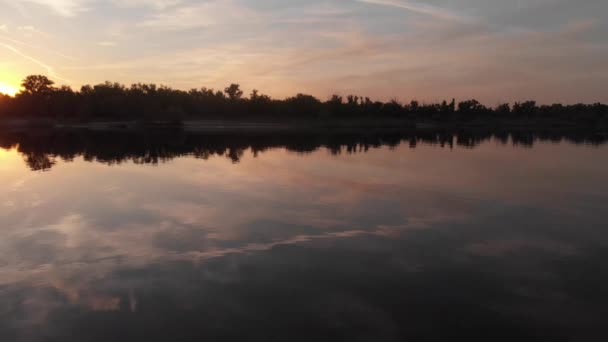 Krásná krajina s odrazem, modrým nebem a žlutým slunečním světlem při východu slunce na řece — Stock video