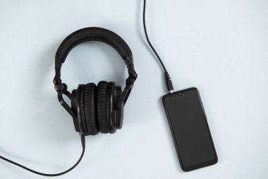 Beyaz arka planda akıllı telefonlu kablosuz kulaklıklar.