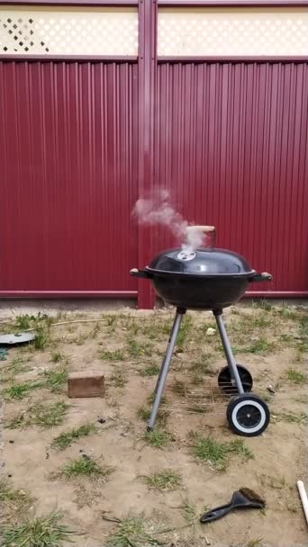 Vertical slow-motion smoke coming from the barbecue grill lid — Stock Video