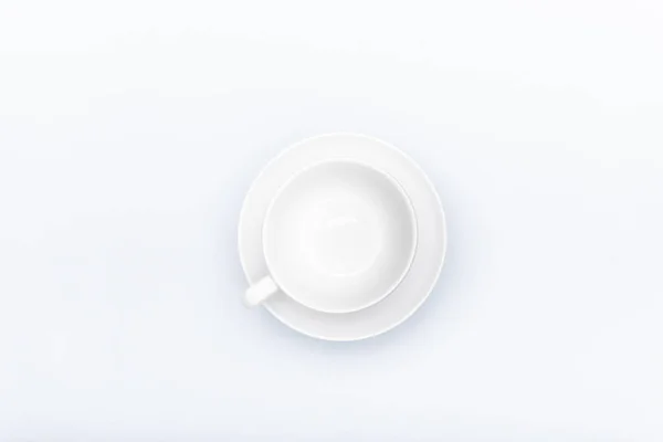 Tasse en porcelaine blanche sur une soucoupe isolée sur un fond blanc — Photo