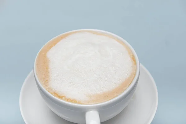 Bagian dari cangkir cappuccino putih diisolasi pada latar belakang biru dengan tempat untuk teks — Stok Foto