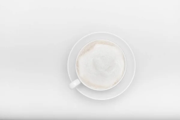 Біла чашка з капучино на білому тлі з місцем для тексту — стокове фото